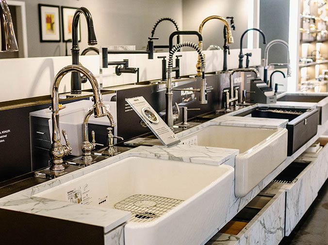 Multiple kitchen sink and faucer styles on display in the Hughes Supply Greenville Showroom