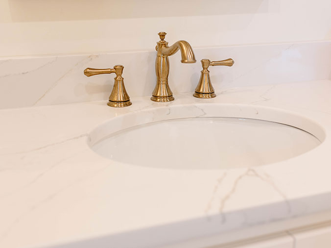 Stone bathroom counter and sink with brass faucet