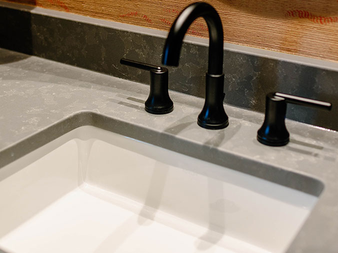 Stone bathroom counter with black faucet and hardware