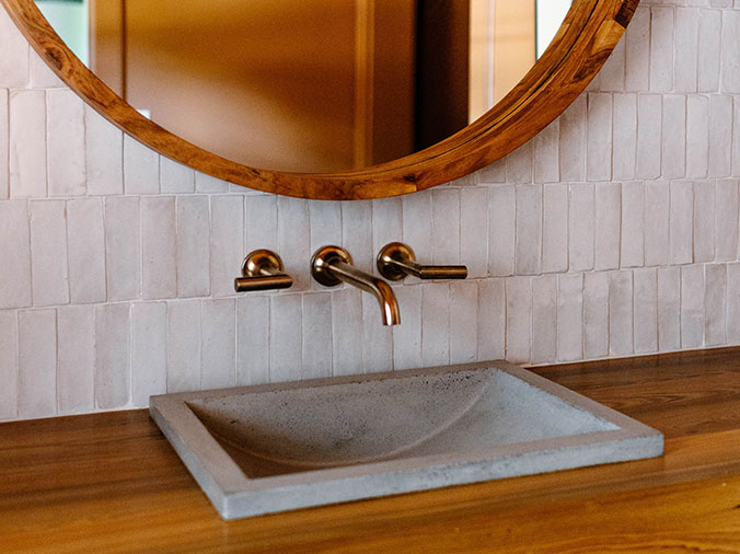 Stone bathroom sink with brushed bronze finish faucet